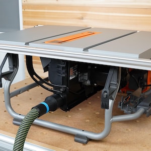 May include: A grey table saw with a black motor and a grey metal stand. The saw has a black and orange power cord and a black and blue dust collection hose.