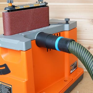 May include: Orange and gray belt sander with a black dust collection port and a green and black dust hose attached.