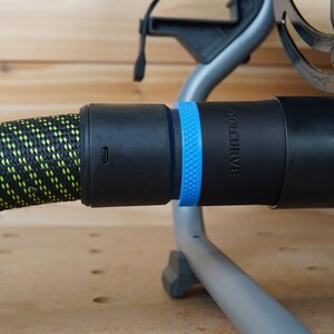 Puede incluir: Una manguera negra y verde con un conector negro y azul. El conector tiene la palabra "TOOLCURVE" impresa.