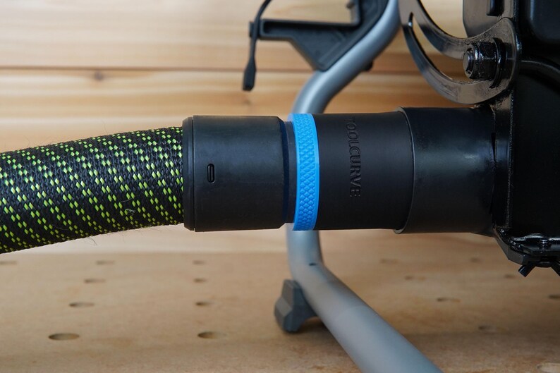 Puede incluir: Una manguera negra y verde con un conector negro y azul. El conector tiene la palabra "TOOLCURVE" impresa.
