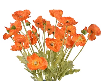 May include: A bouquet of orange artificial poppy flowers with green stems and leaves in a blue vase.