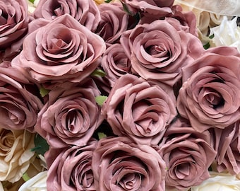 May include: A bouquet of dusty pink silk roses. The roses are arranged in a cluster, with the petals overlapping and creating a soft, romantic look.