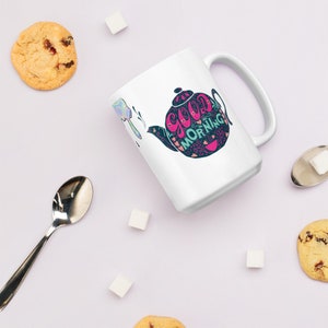 May include: White ceramic mug featuring a colourful illustration of a teapot with the text "Good Morning" in a whimsical font.