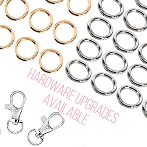 Puede incluir: Primer plano de dos cierres giratorios plateados y una variedad de anillos de salto dorados y plateados. El texto "HARDWARE UPGRADES AVAILABLE" est&aacute; escrito en rosa debajo de los anillos.