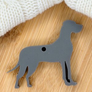 May include: A gray Great Dane dog silhouette ornament with a hole for hanging.