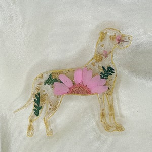 May include: A gold-coloured resin dog silhouette with a pink flower and gold leaf accents.