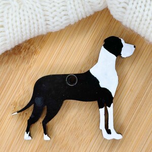 May include: Black and white wooden cutout of a Great Dane dog. The cutout has a hole in the top for hanging.