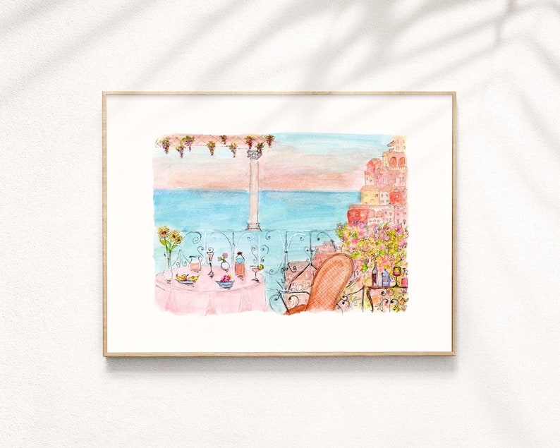 May include: Watercolor painting of a balcony overlooking the ocean with a table set for a meal. The table has a pink tablecloth and is set with glasses, plates, and a bowl of fruit. A chair is positioned at the table, facing the ocean. The background features a cityscape with buildings in shades of pink and orange.