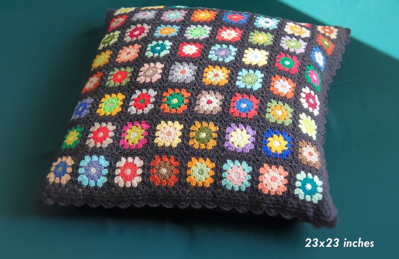 May include: A black crocheted pillow with a colorful granny square pattern. The pillow is 23x23 inches.