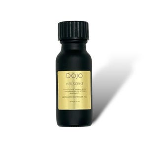 May include: A black glass bottle with a black cap, labeled "DOJO HER SCENT" in gold lettering. The bottle contains aromatic diffuser oil with notes of lychee, vanilla, rose, cashmerean, musk, vetiver, and bergamot. The label also states "AROMATIC DIFFUSER OIL" and "APPROX 15 ML".