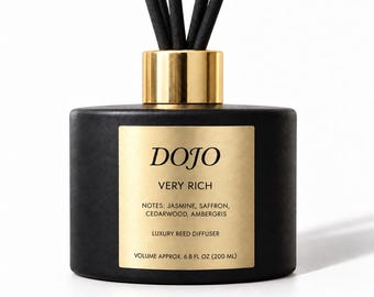 Puede incluir: Un difusor de varillas negro con un cuello dorado y una etiqueta dorada. La etiqueta dice DOJO, VERY RICH, NOTES: JASMINE, SAFFRON, CEDARWOOD, AMBERGRIS, LUXURY REED DIFFUSER, VOLUME APPROX. 6.8 FL OZ (200 ML). Cinco varillas negras sobresalen.