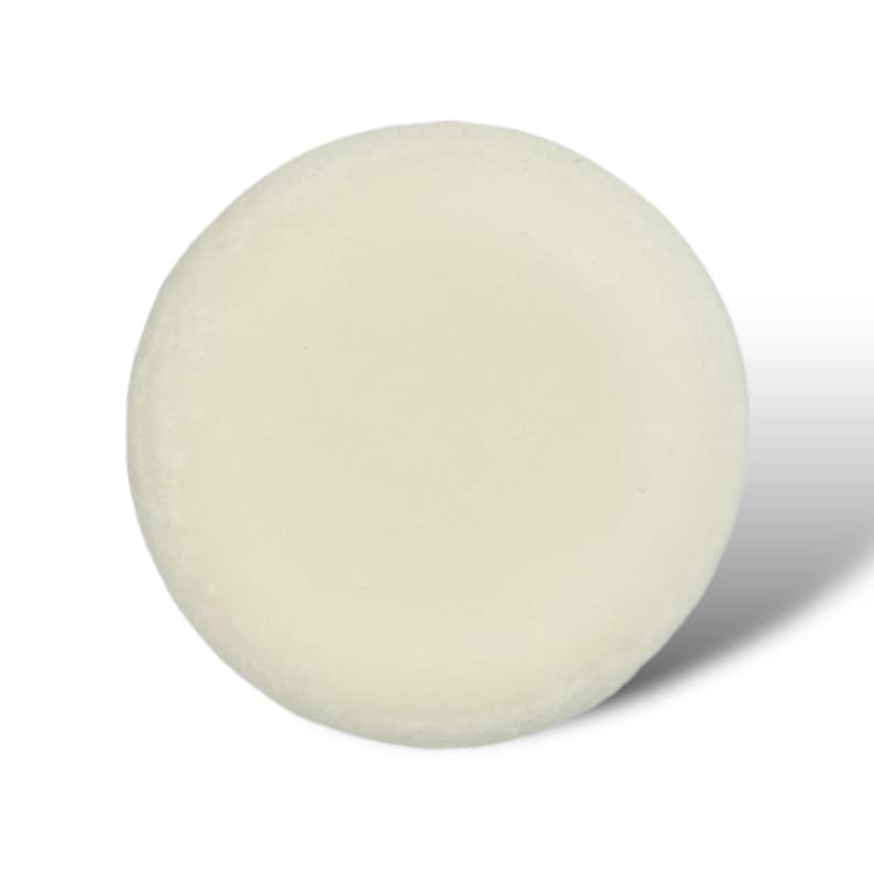 May include: A round, white, solid bar of soap.