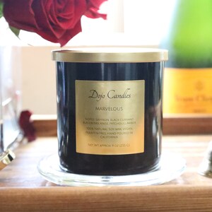 Pu&ograve; includere: Un barattolo di candela nero con un coperchio e un'etichetta dorati. L'etichetta riporta "Dojo Candles" e "Marvelous". La candela &egrave; su un sottobicchiere di vetro trasparente. La candela ha note di zafferano, ribes nero, mora, anice e ambra di Michoac&aacute;n. La candela &egrave; realizzata con cera di soia 100% naturale, &egrave; vegana, senza paraffina e realizzata a mano in California. La candela pesa circa 255 grammi.