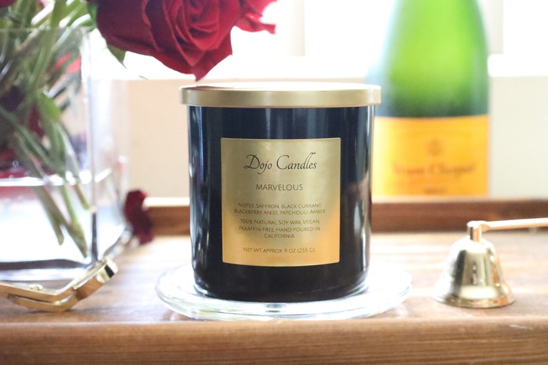 Pu&ograve; includere: Un barattolo di candela nero con un coperchio e un'etichetta dorati. L'etichetta riporta "Dojo Candles" e "Marvelous". La candela &egrave; su un sottobicchiere di vetro trasparente. La candela ha note di zafferano, ribes nero, mora, anice e ambra di Michoac&aacute;n. La candela &egrave; realizzata con cera di soia 100% naturale, &egrave; vegana, senza paraffina e realizzata a mano in California. La candela pesa circa 255 grammi.