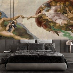 May include: A black and gray bed frame with a gray headboard and a black and white patterned comforter. The headboard features a mural of Michelangelo's The Creation of Adam, a famous Renaissance painting depicting God reaching out to Adam.