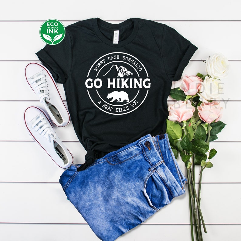 May include: Black t-shirt with a white circle graphic that says "Worst Case Scenario Go Hiking A Bear Kills You".