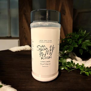Peut inclure: Pot en plastique blanc avec un couvercle noir et une étiquette indiquant "Wick and Glow Candle Company, Sittin Up In My Room, Lush Linen Carpet Refresh, Net Wt. 8 oz."