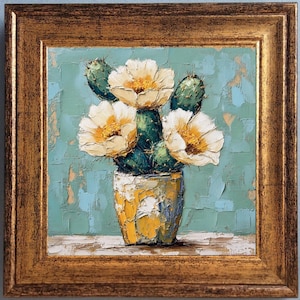 May include: Oil painting of a cactus with white flowers in a yellow and white pot. The painting is set against a textured teal background and framed in a gold-colored frame. The artwork is a still life.