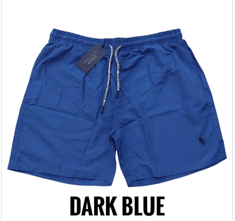 May include: Dark blue shorts with a drawstring waist and a small logo on the lower right leg. The shorts have a tag attached with the brand name. The text "DARK BLUE" is at the bottom of the image.