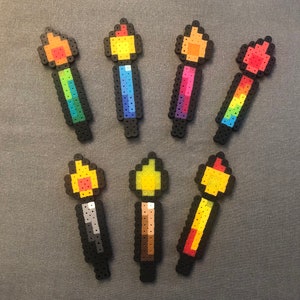 May include: A set of ten colorful pixel art candles, each with a different color flame. The candles are made of plastic beads and are approximately 2 inches tall.