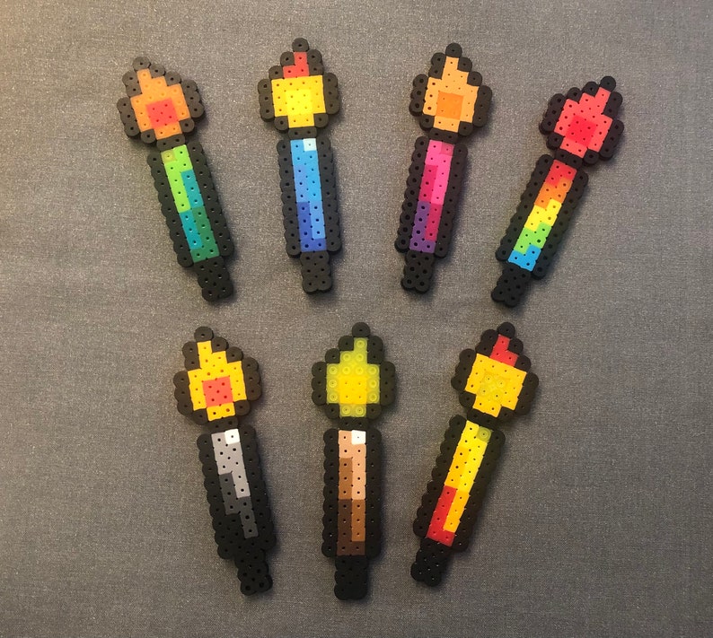 May include: A set of ten colorful pixel art candles, each with a different color flame. The candles are made of plastic beads and are approximately 2 inches tall.
