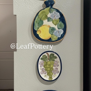 Puede incluir: Una taza de cerámica blanca con un asa negra y el texto "But First, Coffee" en negrita negra. La taza se encuentra sobre un fondo neutro, resaltando su diseño simple.