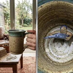 Może przedstawiać: Ręcznie robiony ceramiczny kubek z nakrapianym, brązowym korpusem i turkusowym rantem i uchwytem. Kubek jest wypełniony gorącym napojem, z którego unosi się para. Wnętrze kubka zdobi fantazyjna ceramiczna figurka.