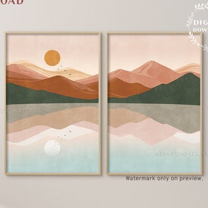 May include: Two digital prints of abstract landscape art with mountains, water, and a sun. The prints are in a minimalist style with muted colors of pink, orange, brown, and green. The prints are framed in a light wood frame.