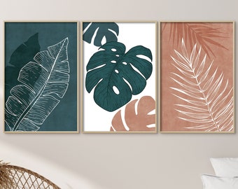 May include: Three framed prints with a minimalist design featuring white line drawings of tropical leaves on a teal, white, and peach background. The prints are displayed on a white wall above a wicker chair and a bed with a white duvet and a beige throw blanket.