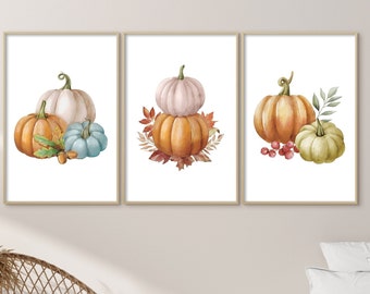 May include: Three watercolor paintings of pumpkins. The first painting features a white pumpkin, a blue pumpkin, and an orange pumpkin. The second painting features a white pumpkin, an orange pumpkin, and brown leaves. The third painting features an orange pumpkin, a green pumpkin, and red berries.