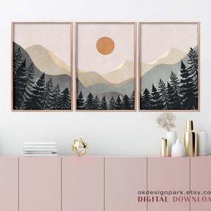 K&ouml;nnte beinhalten: Ein Set aus drei digitalen Drucken mit einer minimalistischen Landschaft mit Bergen, einer Sonne und einem Wald aus dunklen B&auml;umen. Die Drucke sind in Braun-, Beige- und Blaut&ouml;nen gehalten.