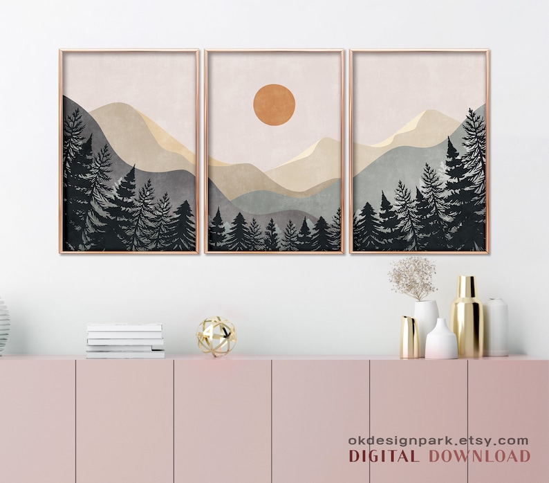 K&ouml;nnte beinhalten: Ein Set aus drei digitalen Drucken mit einer minimalistischen Landschaft mit Bergen, einer Sonne und einem Wald aus dunklen B&auml;umen. Die Drucke sind in Braun-, Beige- und Blaut&ouml;nen gehalten.