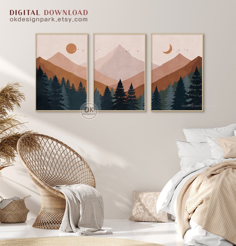 May include: Three abstract landscape prints with a mountain range, trees, and a sun, moon, or crescent moon in the sky. The prints are in a minimalist style with muted colors of brown, orange, and blue.