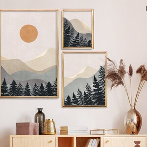 K&ouml;nnte beinhalten: Drei digitale Drucke einer Berglandschaft mit einer Sonne im oberen Druck. Die Drucke sind in Gold gerahmt und haben einen wei&szlig;en Hintergrund. Die Drucke sind in einer Reihe an einer wei&szlig;en Wand angeordnet.