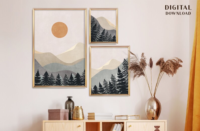 K&ouml;nnte beinhalten: Drei digitale Drucke einer Berglandschaft mit einer Sonne im oberen Druck. Die Drucke sind in Gold gerahmt und haben einen wei&szlig;en Hintergrund. Die Drucke sind in einer Reihe an einer wei&szlig;en Wand angeordnet.