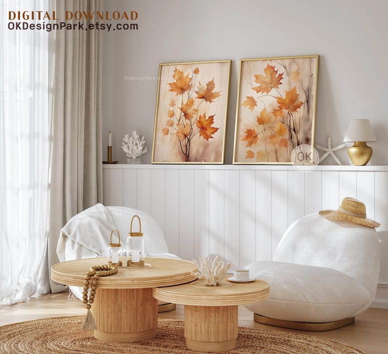 May include: Two framed watercolor paintings of autumn leaves in shades of orange and brown. The paintings are hanging on a white wall above a white couch and a wooden coffee table. The text "OKDesignPark.etsy.com" is visible in the top left corner of the image.