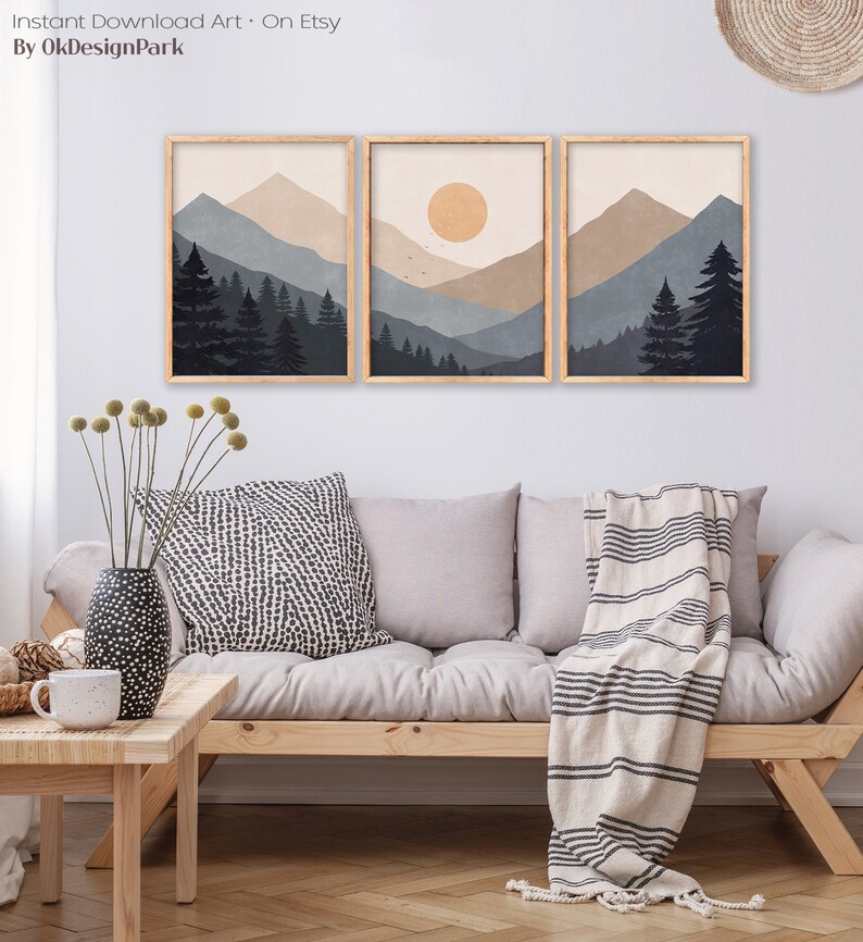 Pode incluir: Tr&ecirc;s impress&otilde;es emolduradas de uma paisagem de montanha minimalista com um sol na impress&atilde;o central. As impress&otilde;es est&atilde;o em uma sala de estar com um sof&aacute;, almofadas e um cobertor.
