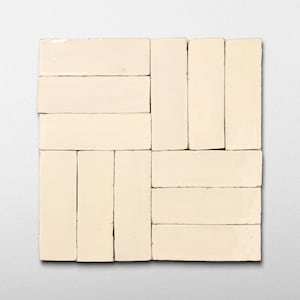May include: A square arrangement of off-white rectangular tiles. The tiles are laid out in a pattern, with some oriented horizontally and others vertically, creating a textured surface. The tiles have a slightly uneven surface and a matte finish.