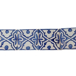 Könnte beinhalten: Eine Reihe von fünf blauen und weißen Keramikfliesen mit einem sich wiederholenden geometrischen Muster. Die Fliesen sind in einer horizontalen Linie angeordnet und zeigen ein florales Design.