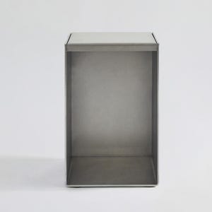 May include: A silver metal shelf unit with an open design. The shelf is made of metal and has a simple, modern design.