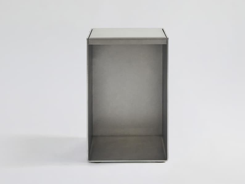 May include: A silver metal shelf unit with an open design. The shelf is made of metal and has a simple, modern design.