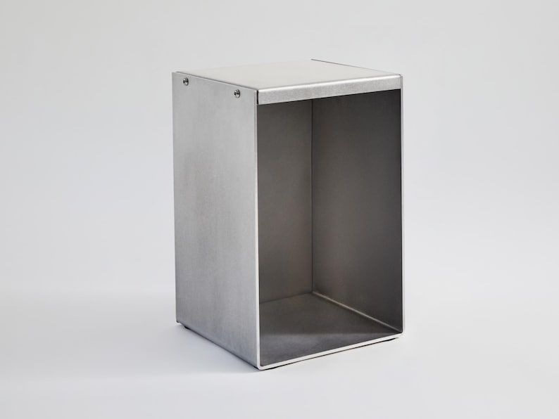 May include: A silver metal storage box with a square shape and open top. The box is made of metal and has a brushed finish.