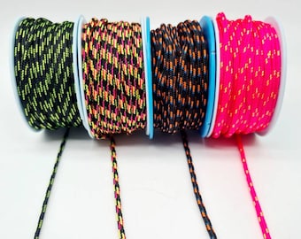 May include: Four spools of colorful braided cord, each with a different color combination. The cords are black with neon green, black with orange and yellow, black with orange and blue, and hot pink with orange. The cords are unraveled and hanging down from the spools.
