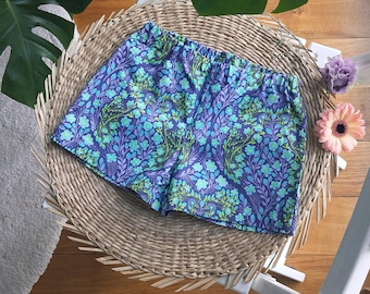 Kindershorts van katoen met een blauw en groen bloemenpatroon.