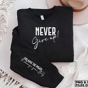 May include: Black sweatshirt with the text "NEVER give up!" on the front and "YOU HAVE THE POWER to change your story" on the sleeve.