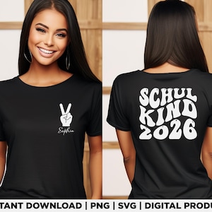 Könnte beinhalten: Ein schwarzes T-Shirt mit einer weißen Grafik eines Friedenszeichens und dem Namen Sophia auf der linken Brust. Die Rückseite des Shirts zeigt den weißen Text SCHUL KIND 2026 in einer wellenförmigen Retro-Schrift auf schwarzem Grund.