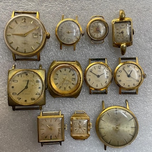 Puede incluir: Una colección de relojes de pulsera vintage dorados con diversas formas y tamaños de esfera. Los relojes muestran signos de desgaste, algunos con números romanos y visualización de fecha. La colección incluye esferas redondas, cuadradas y rectangulares.