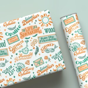 May include: White wrapping paper and a rolled tube featuring a repeating pattern of orange and teal text and illustrations. The text includes phrases like "The Life of a Showgirl" and "Actually Romantic."
