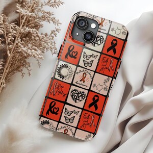 May include: A phone case with a grid pattern featuring red, black, and cream squares. The squares contain various designs, including ribbons, butterflies, hearts, and the words "Keep Fighting" and "Faith and Hope".