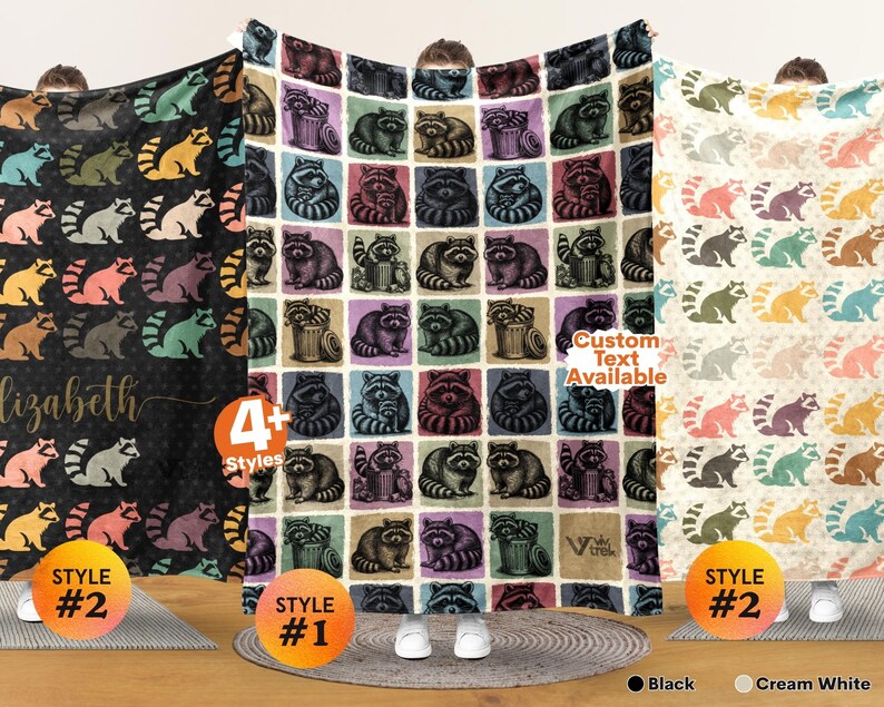 May include: Three fleece blankets featuring raccoon patterns. The left blanket is black with colorful raccoons and the name Elizabeth. The center blanket has a grid of raccoons in squares. The right blanket is cream white with colorful raccoons.